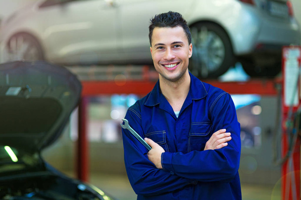 Mechanic working on car in auto repair shop - Photo, Image