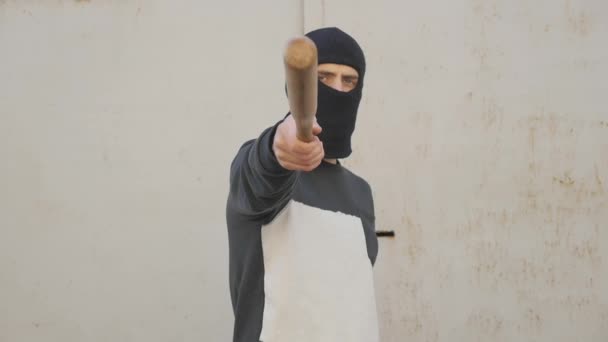 Aggressive masked man with a baseball bat - Materiał filmowy, wideo