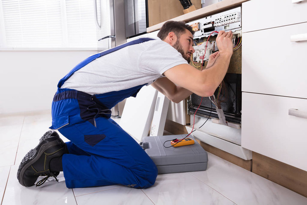 Male Technician Examining Dishwasher - Фото, зображення