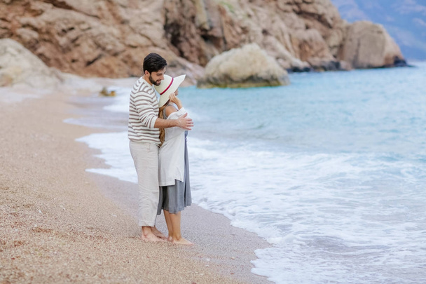 happy young couple hugging standing on sea beach, full length - Foto, imagen