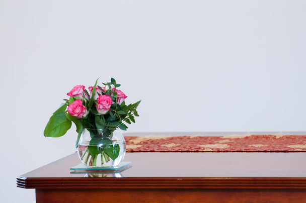 leere Raumausstattung mit weißen Wänden und Holztisch mit Blume - Foto, Bild