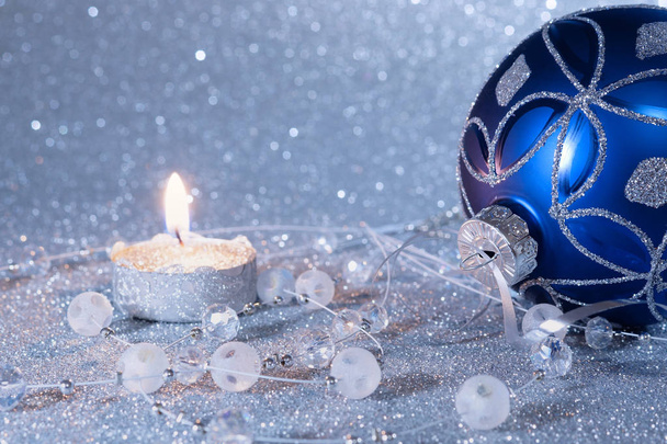 Blue Christmas ball and candle on a silver background. New Year's composition. - Valokuva, kuva