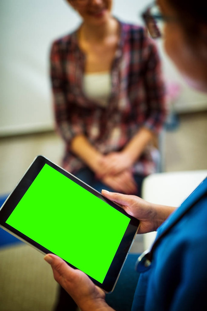 tablet pc ile boş düzenlenebilir yeşil ekran tutan bulanık kadın - Fotoğraf, Görsel