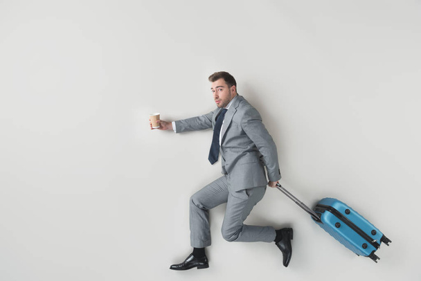 overhead view of businessman with coffee to go and suitcase isolated on grey - Fotoğraf, Görsel