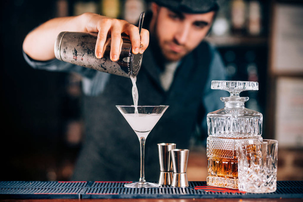 Martini preparation. Dry martini details, close up of alcoholic beverage at bar - Photo, image