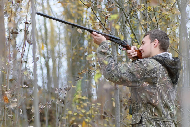 Hombre en camuflaje y con armas en un cinturón forestal en un hun de primavera
 - Foto, imagen