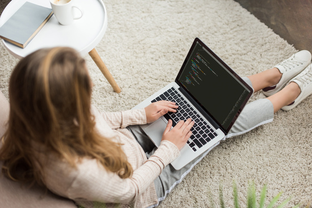 high angle view of young female developer coding with laptop at home - Φωτογραφία, εικόνα