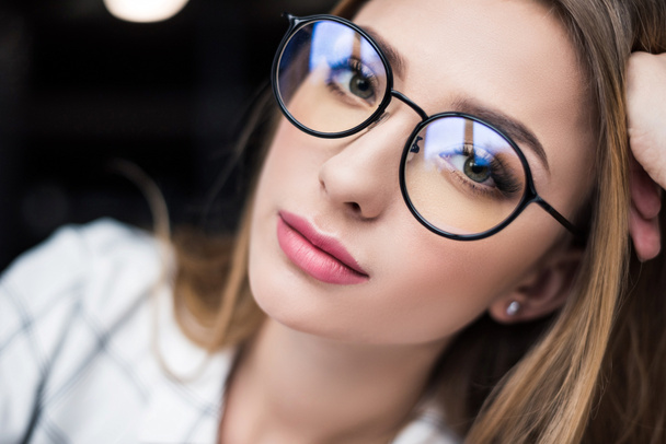 gyönyörű fiatal nő a szemüvegek látszó-on fényképezőgép makró portréja - Fotó, kép