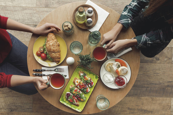 top view of people drinking tea and having breakfast together - Photo, Image