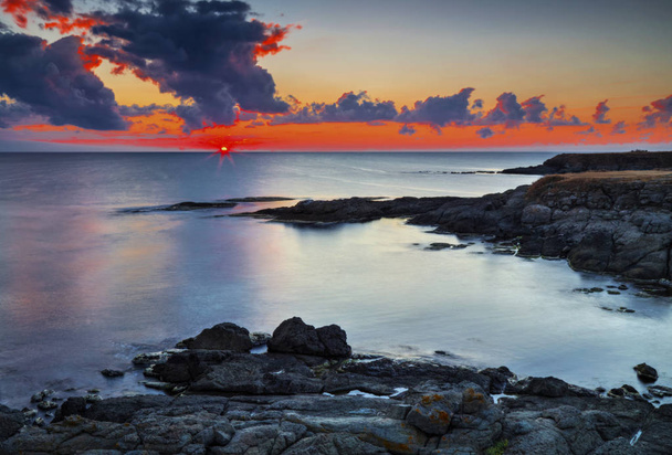 Beautiful sunrise on rocky shore and dramatic sky clouds - Photo, Image