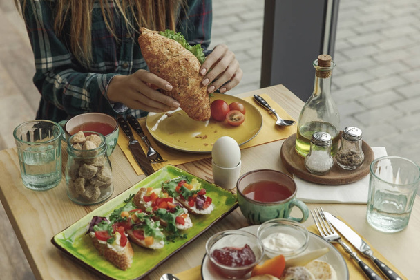 обрезанный снимок девушки, поедающей свежий круассан за завтраком
 - Фото, изображение