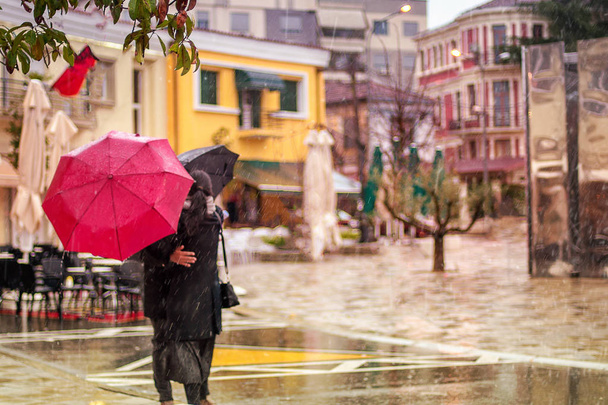 two people hugging in a street under the rain for a good bye - Foto, Imagen