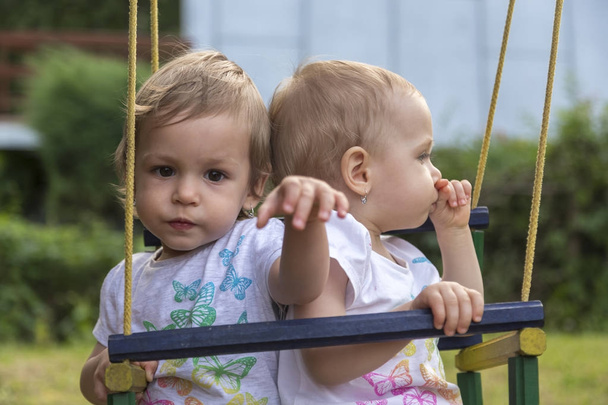 twin outdoors on swing - Φωτογραφία, εικόνα