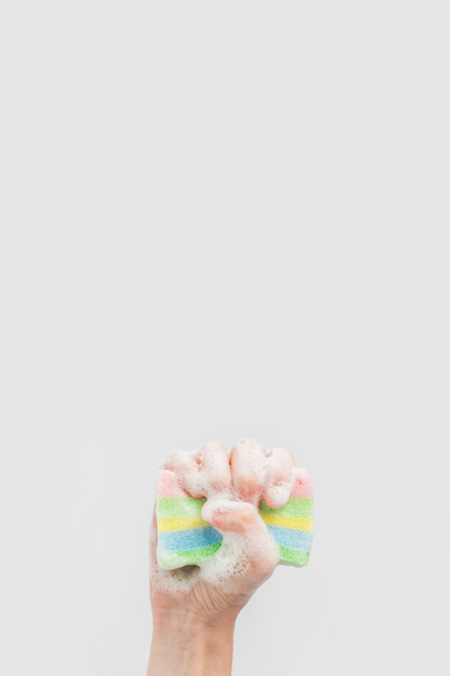 vista recortada de la mano que sostiene la esponja de lavado con espuma, aislada en blanco
 - Foto, Imagen