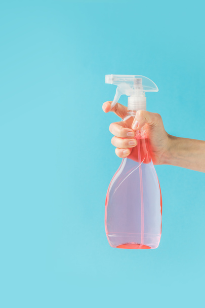 cropped view of hand holding spray bottle, isolated on blue - Photo, Image