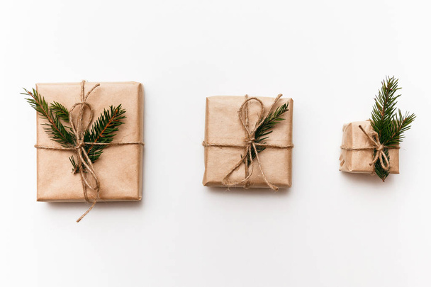 Three Vintage gift boxes with spruce branches on white isolated background, top view - Fotó, kép
