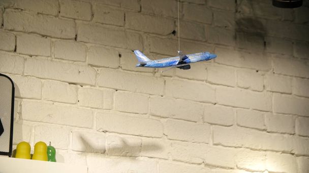 Modelo de juguete colgante de avión, fondo de pared de ladrillo blanco
 - Foto, Imagen