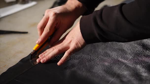 Leatherworker is met behulp van mes te snijden van leder. - Video