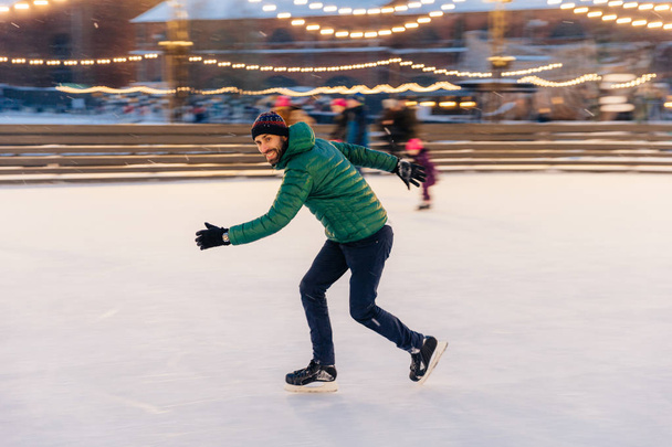 Masculino en velocidad demuestra sus habilidades de patinaje, se divierte en rin
 - Foto, imagen