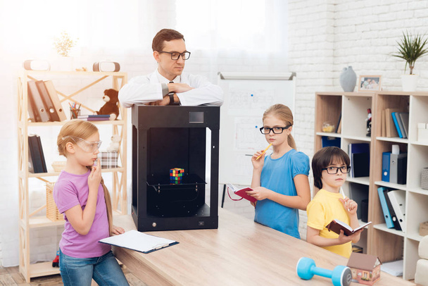 Children print different items on a 3d printer with a teacher. - Foto, afbeelding