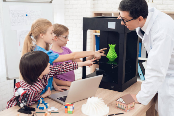 Children print different items on a 3d printer with a teacher. - Foto, Imagen