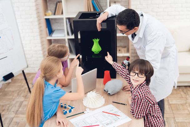 Children print different items on a 3d printer with a teacher. - Foto, Imagem