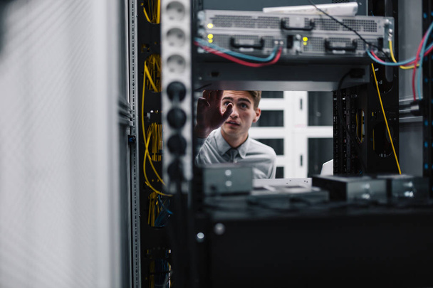 Young business man with laptop working in data center - Foto, Imagen