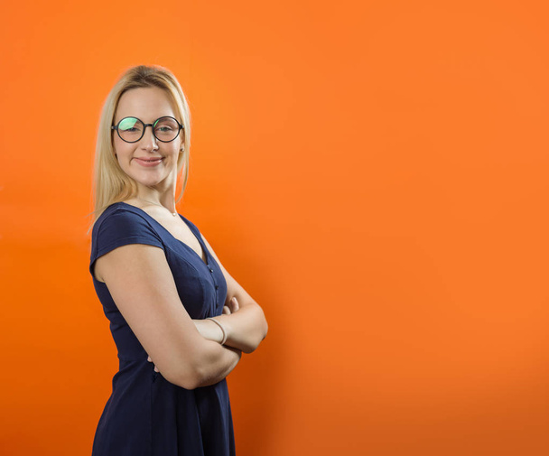 Young Caucasian woman with smiley face wearing glasses on orange background. Vintage style - Fotó, kép