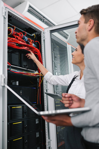 Team of technicians working together on servers at the data centre - Foto, Imagem