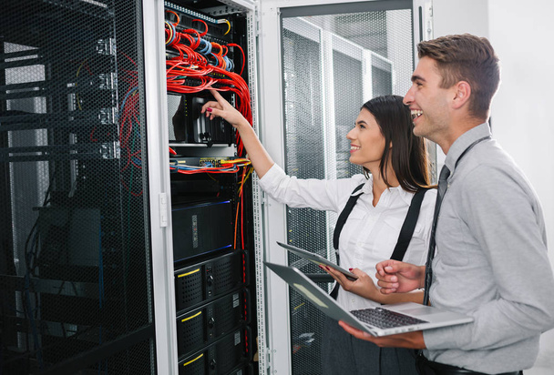 Team of technicians working together on servers at the data centre - 写真・画像