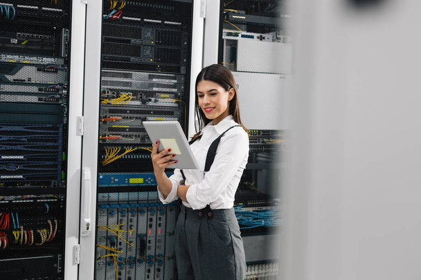 Young engineer businesswoman in network server room - Foto, afbeelding