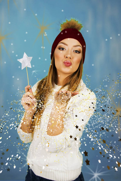 kaunis tyttö puhaltaa tähti kultainen pöly tehdä toive hyvää lomaa ja hyvää joulua käsite
 - Valokuva, kuva
