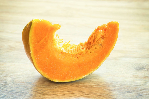 Tranche de citrouille mûre orange sur un bureau en bois
 - Photo, image