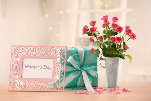 Gift box, flowers and frame with text  MOTHER'S DAY on table - Photo, image
