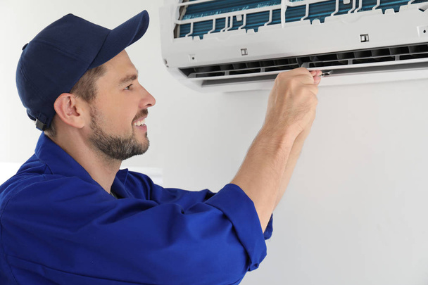 technician repairing air conditioner  - Фото, изображение