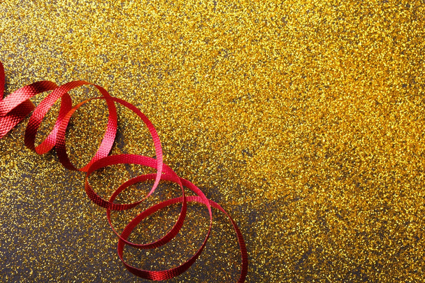 Krullend rood serpentine op glitter achtergrond - Foto, afbeelding