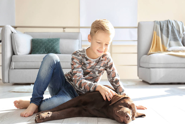 Cute little boy with dog on floor at home - Zdjęcie, obraz