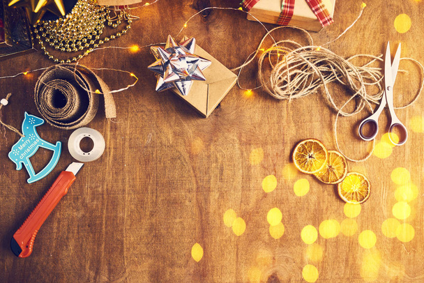 Fondo festivo con diversi accessori natalizi, forbici, nastri, coltelleria, nastro adesivo
 - Foto, immagini