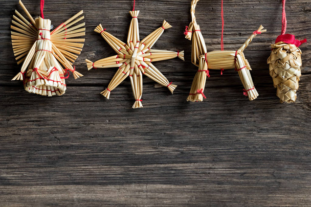 Sfondo semplice di Natale ornamenti di paglia appesi sopra un corteggiamento
 - Foto, immagini