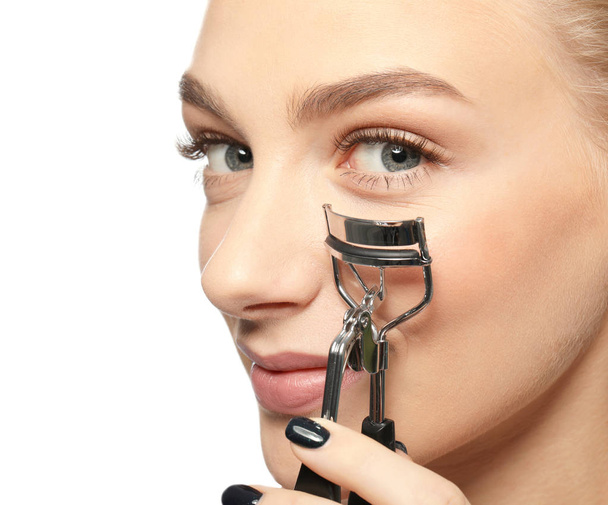 Beautiful young woman with eyelash curler  - 写真・画像