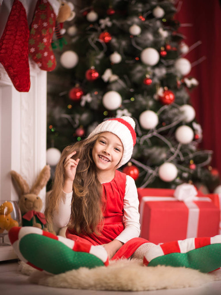 Belle fille en bonnet de Père Noël couché sur le sol, plan studio
. - Photo, image