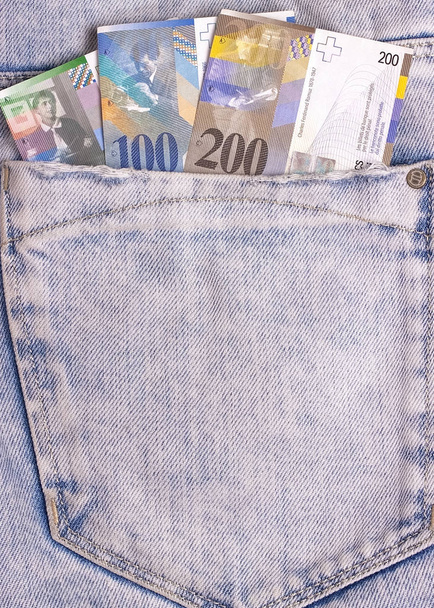 Schweizer Franken-Scheine in grauer Jeanstasche. - Foto, Bild