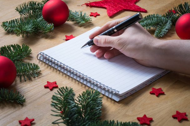 Escribiendo en un bloc de notas vacío con decoraciones navideñas y abeto b
 - Foto, Imagen