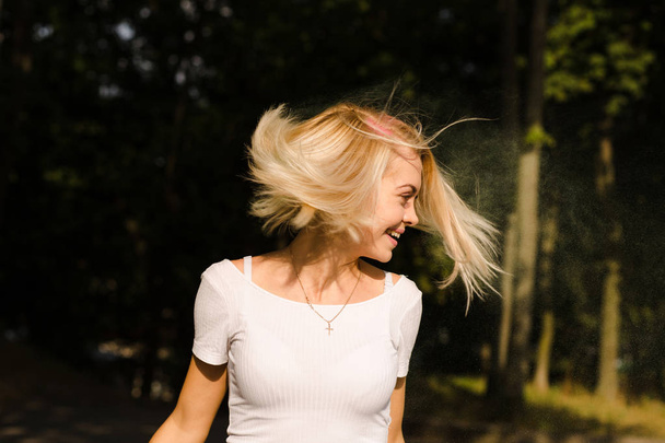 Happy young woman in white t shirt with hair  in wind posing on  - Fotoğraf, Görsel