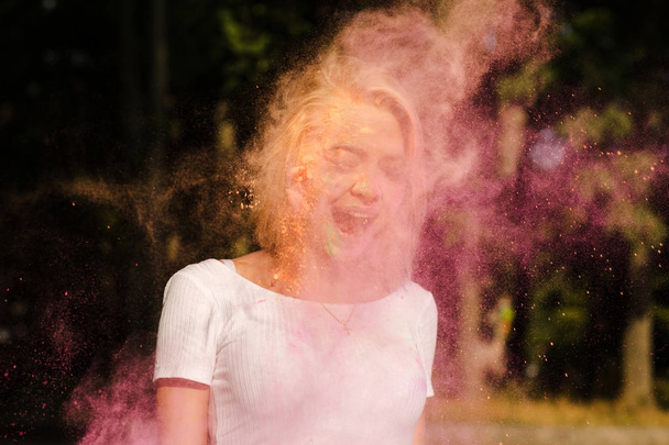 Attractive young woman in white t shirt with exploding colorful  - Photo, Image