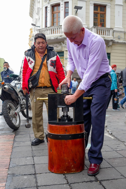 QUITO, ECUADOR NOVEMBER, 28, 2017: Unidentified people at the historical center with a wedge coin machine at old town Quito in northern Ecuador in the Andes mountains - 写真・画像