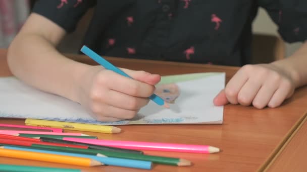 Little girl draws the pictures using color pencils - Filmati, video