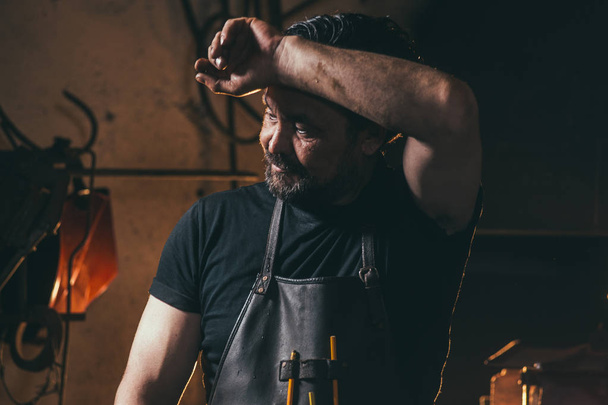 blacksmith wipe sweat in workshop - Foto, imagen