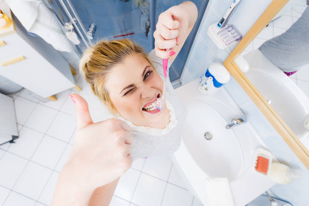 Woman brushing cleaning teeth in bathroom - Fotoğraf, Görsel