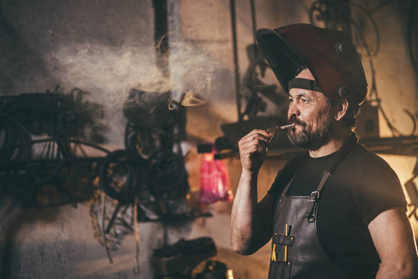 blacksmith portrait with beard in workshop - Valokuva, kuva